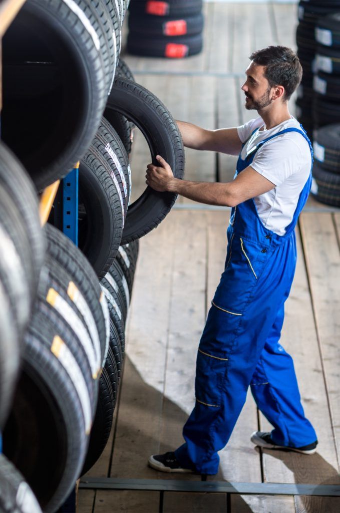 Auto mechanic picking out a tyre from a tyre rack - Tyres Kent